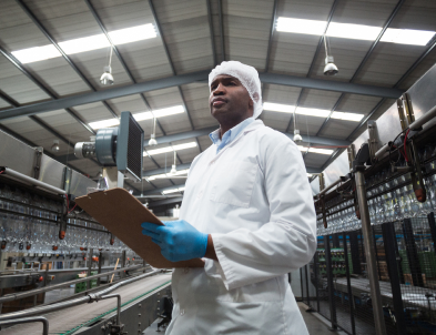 Man in beverage manufacturing plant with clipboard